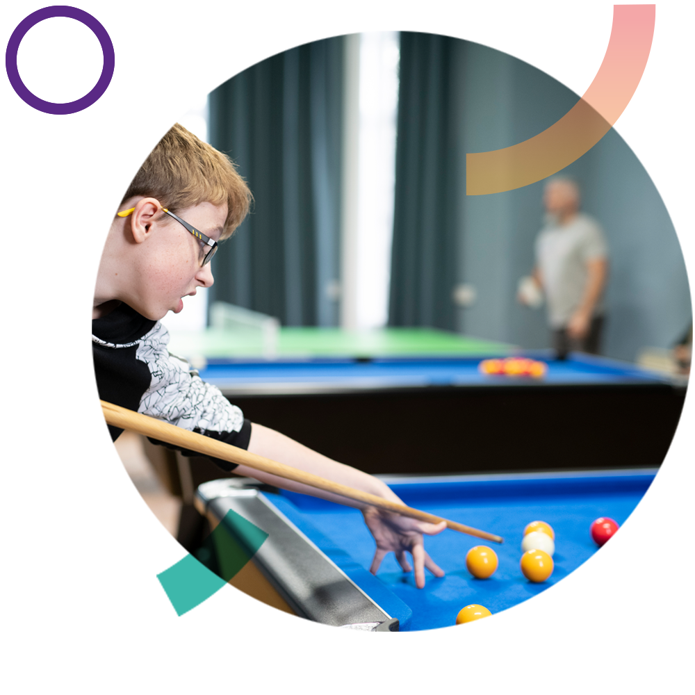 Young boy playing pool